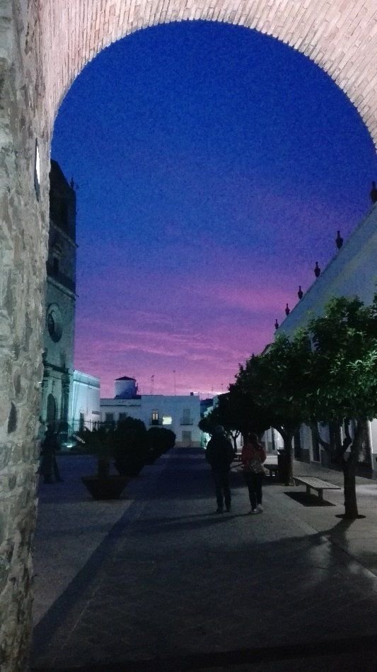 Un arco del casco antiguo de Cáceres al anochecer