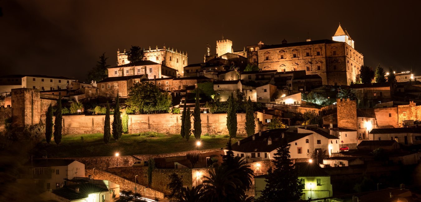 El casco antiguo de Cáceres iluminado al anochecer, visto desde la Ribera